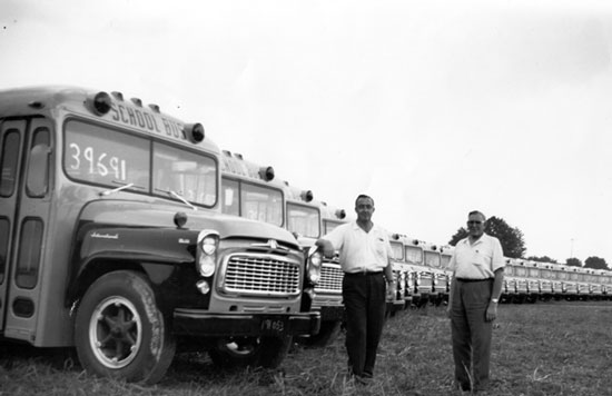 Robert McIlwain, Sr. (left) buying school buses from Paul Myers of Myers Equipment in 1960